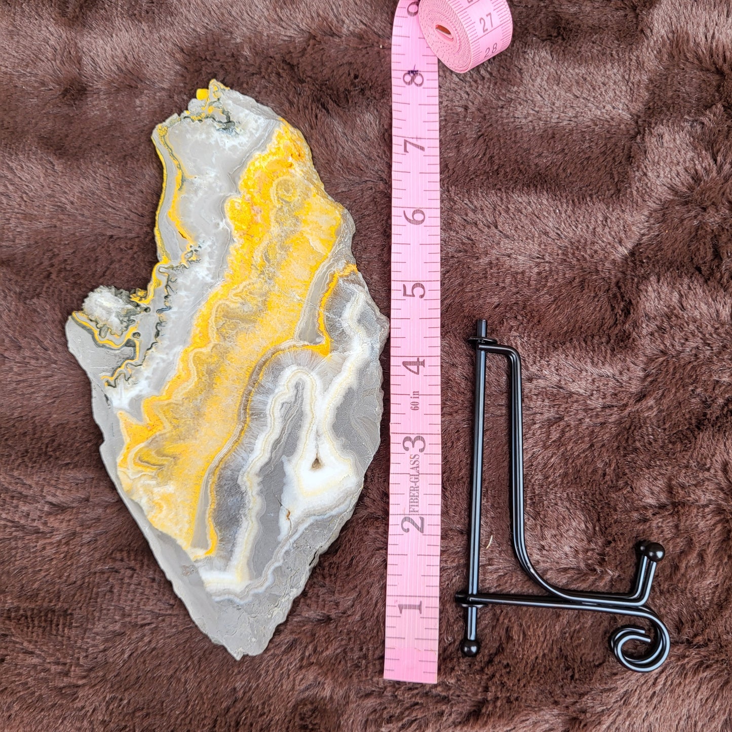 Bumblebee Jasper Slabs showcasing vibrant yellow and gray patterns with measuring tape for size reference
