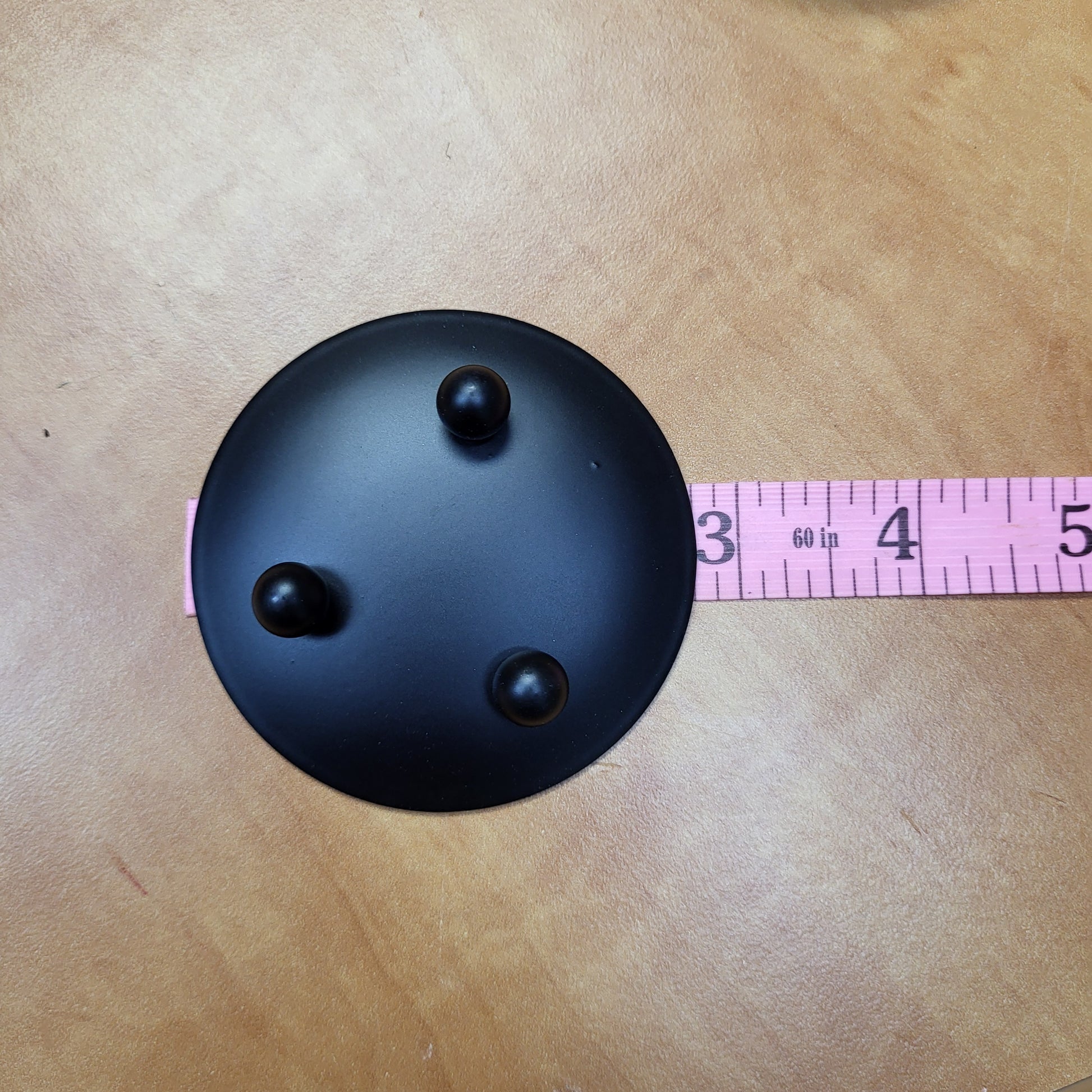 Black candle dish with three feet for stability, ideal for displaying candles elegantly