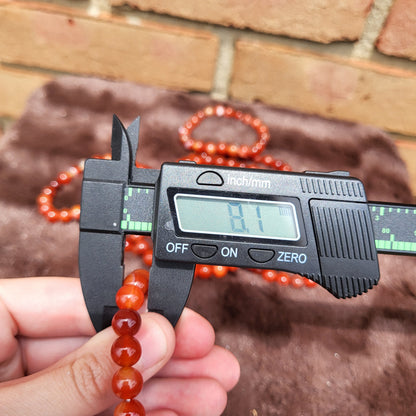 Measuring a Carnelian bracelet with calipers to showcase its size and quality at Different Branches Crystal Gift Shop
