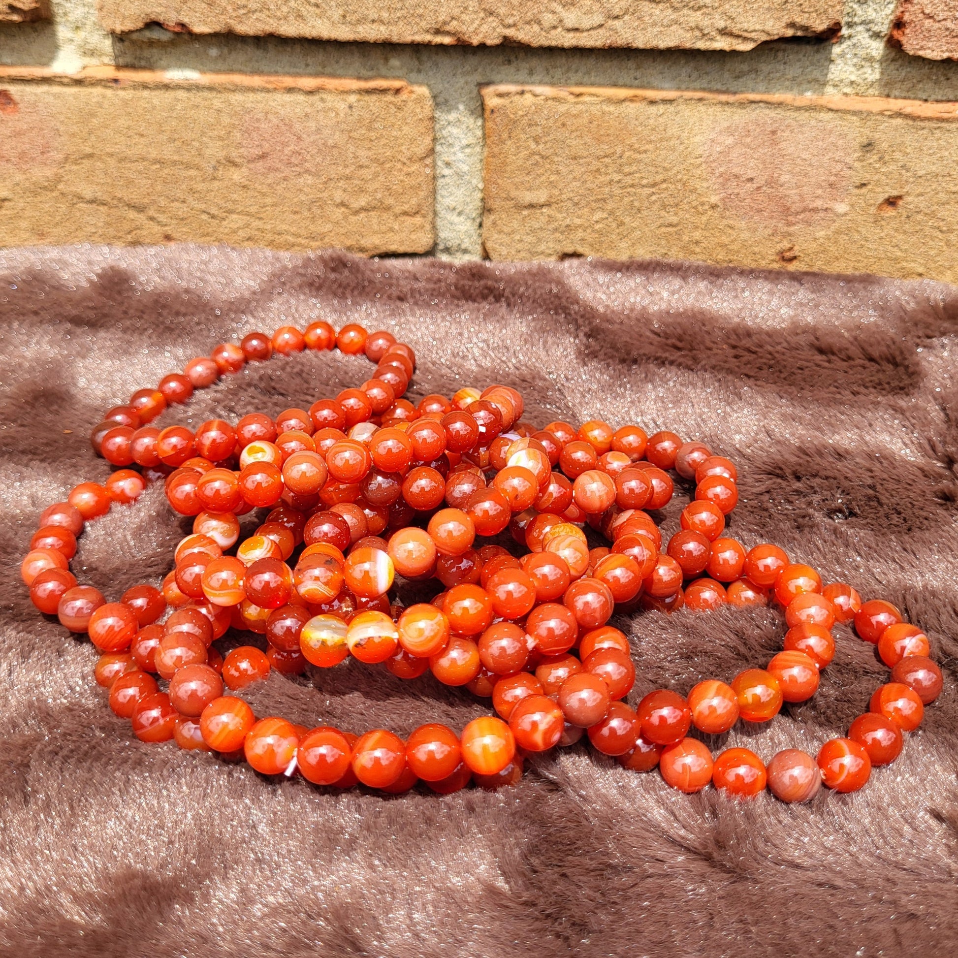 Carnelian bracelet set featuring multiple strands of vibrant red-orange beads for stylish accessories