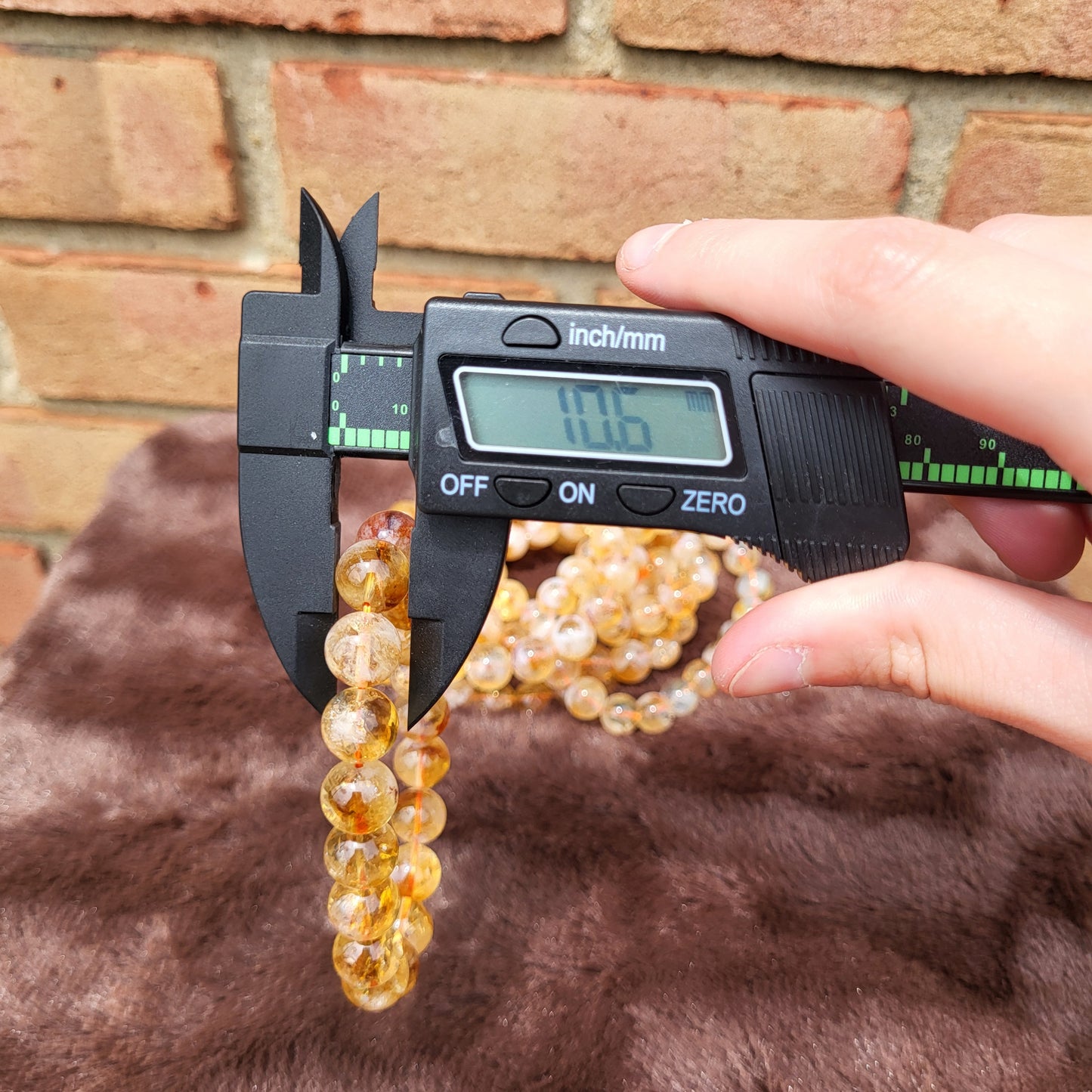 Measuring a Citrine bracelet with a caliper for precise sizing and quality assurance