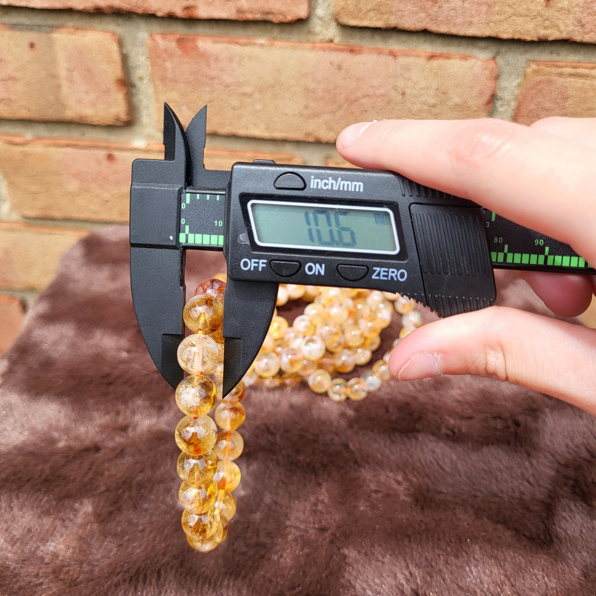 Measuring a Citrine bracelet with a caliper for precise sizing and quality assurance