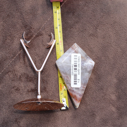 Crazy Lace Agate Diamond crystal from Different Branches LLC placed next to a measuring tape and metal stand