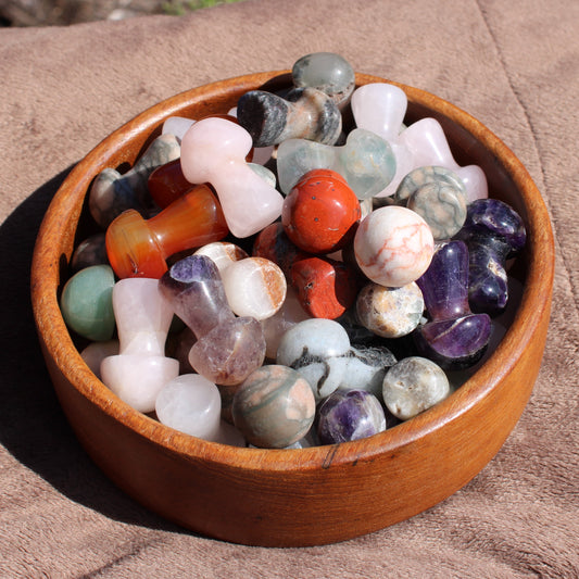 Colorful assortment of polished Crystal Mushroom Carving pieces displayed in a wooden bowl