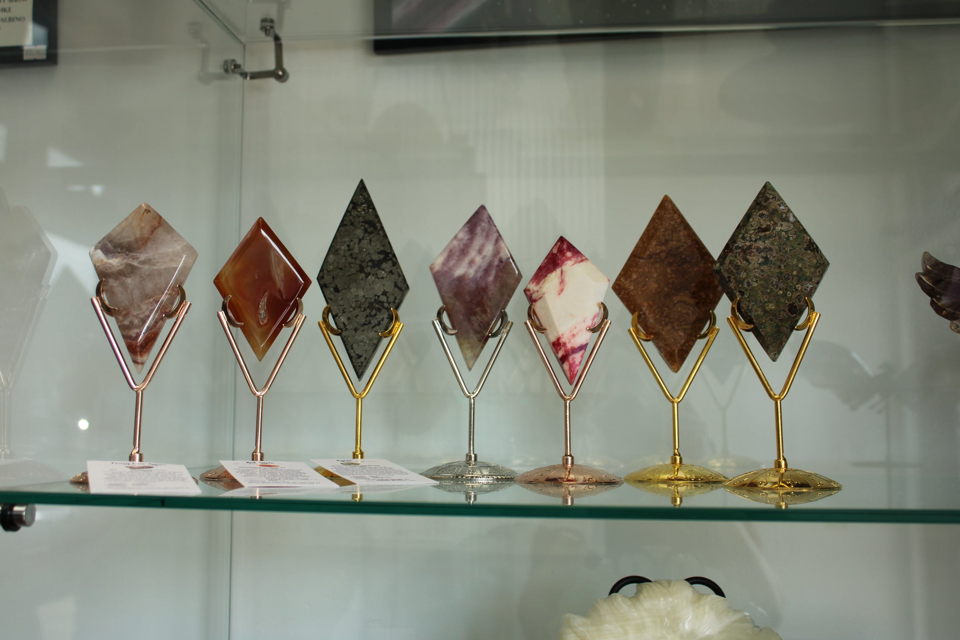Set of seven Diamond crystals displayed on gold and silver metal stands by Different Branches LLC
