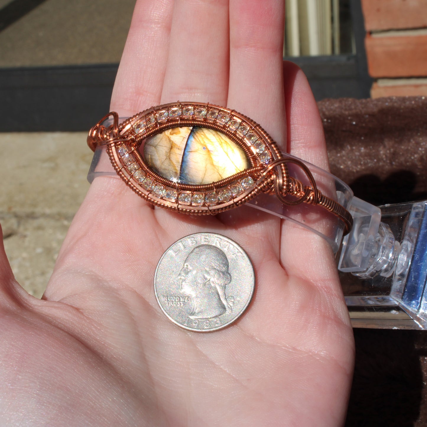 Handcrafted Dragon Eye Labradorite Bracelet with intricate design and colorful stone detail, displayed alongside a quarter