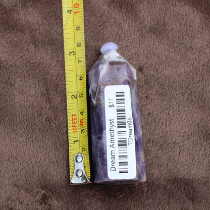 Dream Amethyst Tower crystal by Different Branches LLC shown next to tape measure for size