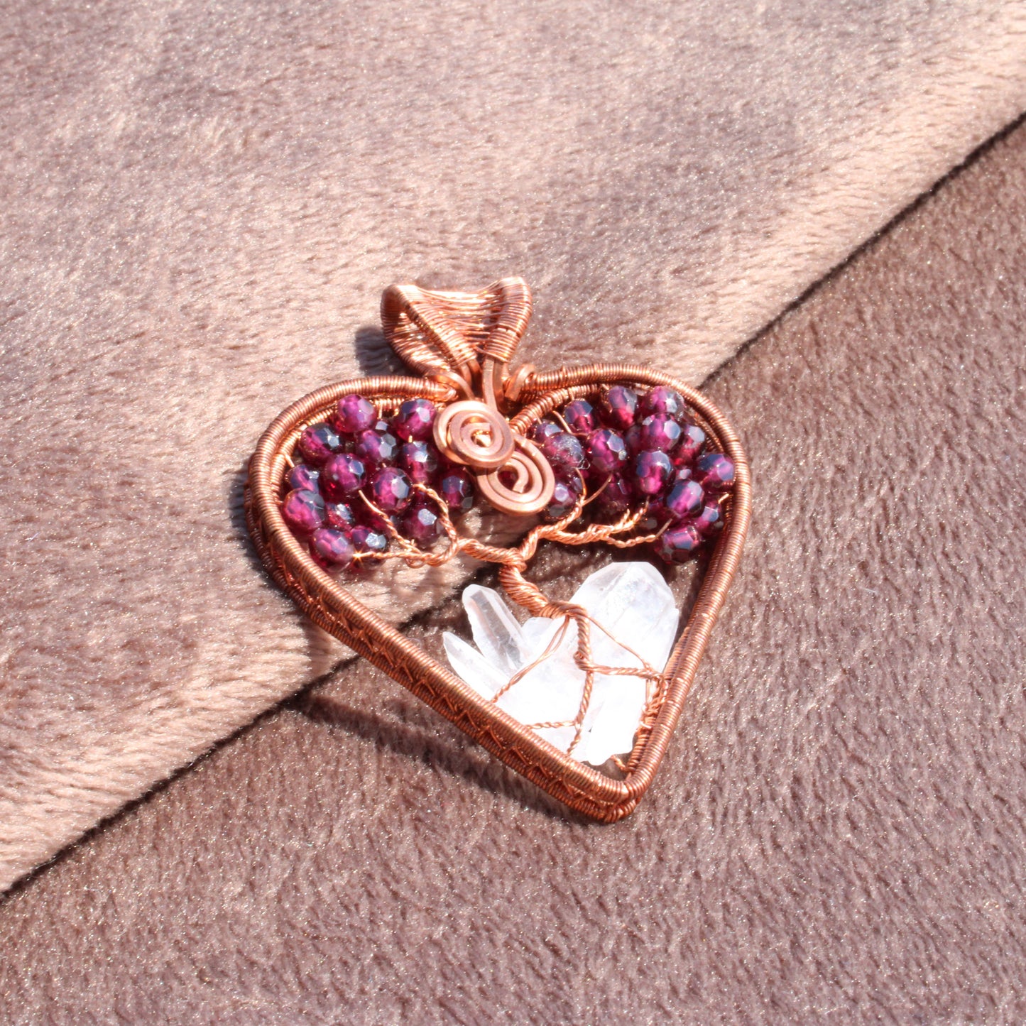 Handcrafted garnet heart tree of life pendant with intricate wire wrapping and natural stone accents