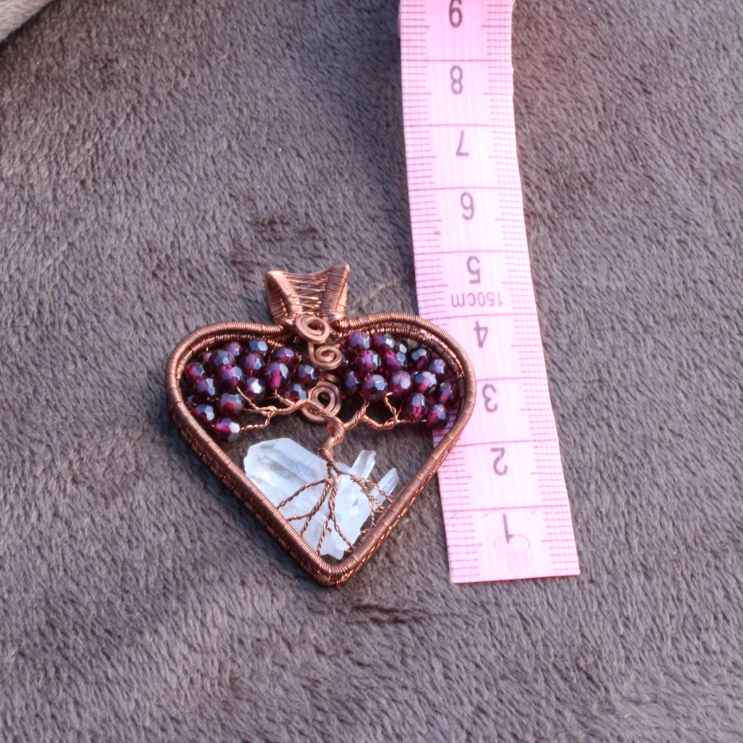 Garnet heart tree of life pendant with intricate design and clear crystal base