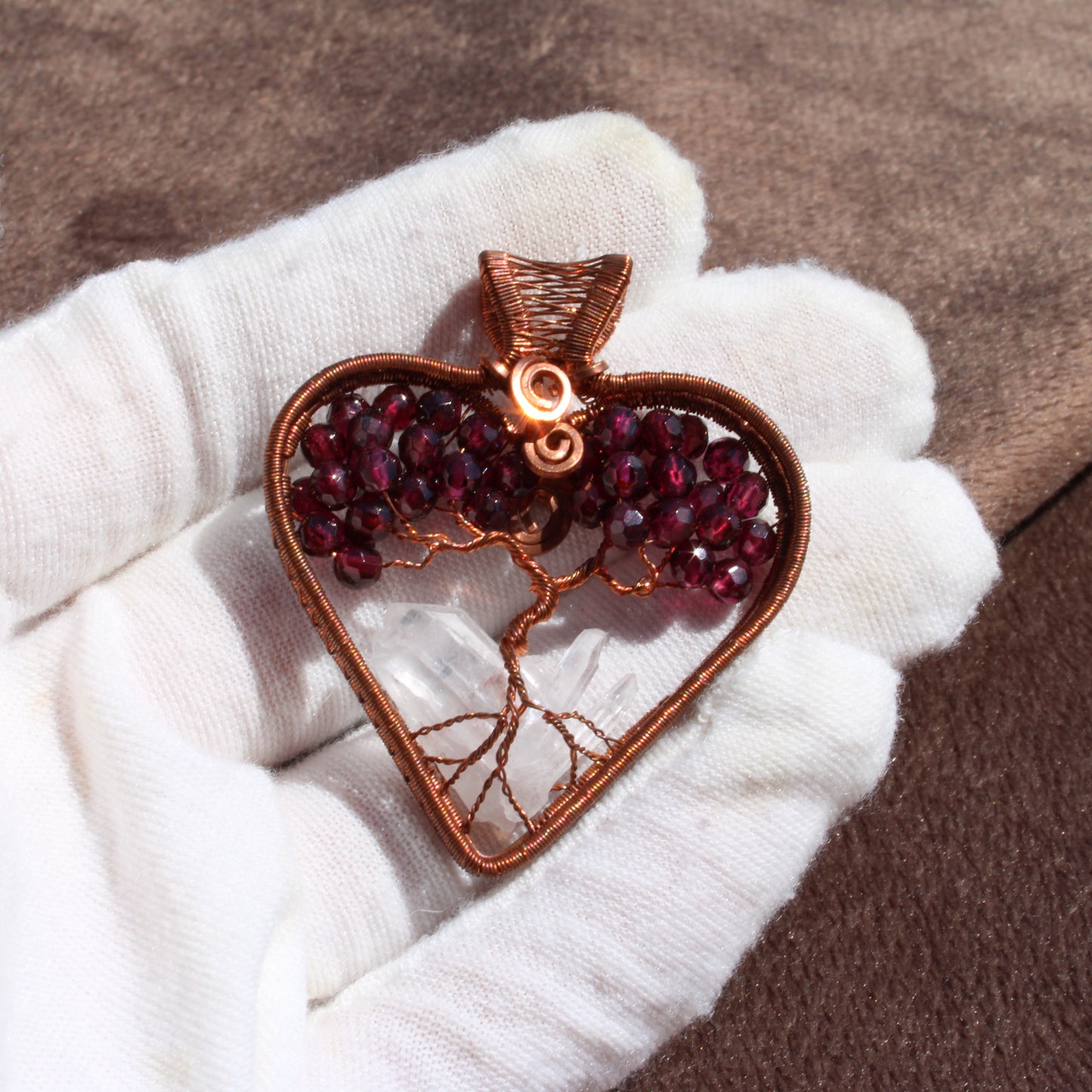 Garnet heart tree of life pendant with intricate copper wire design and vibrant garnet gemstones