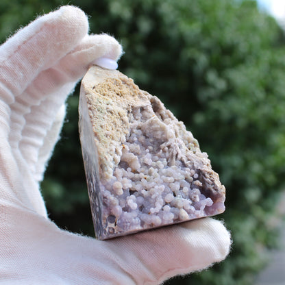 Grape Agate Tower crystal held in gloved hand showing purple botryoidal formations and rough beige surface
