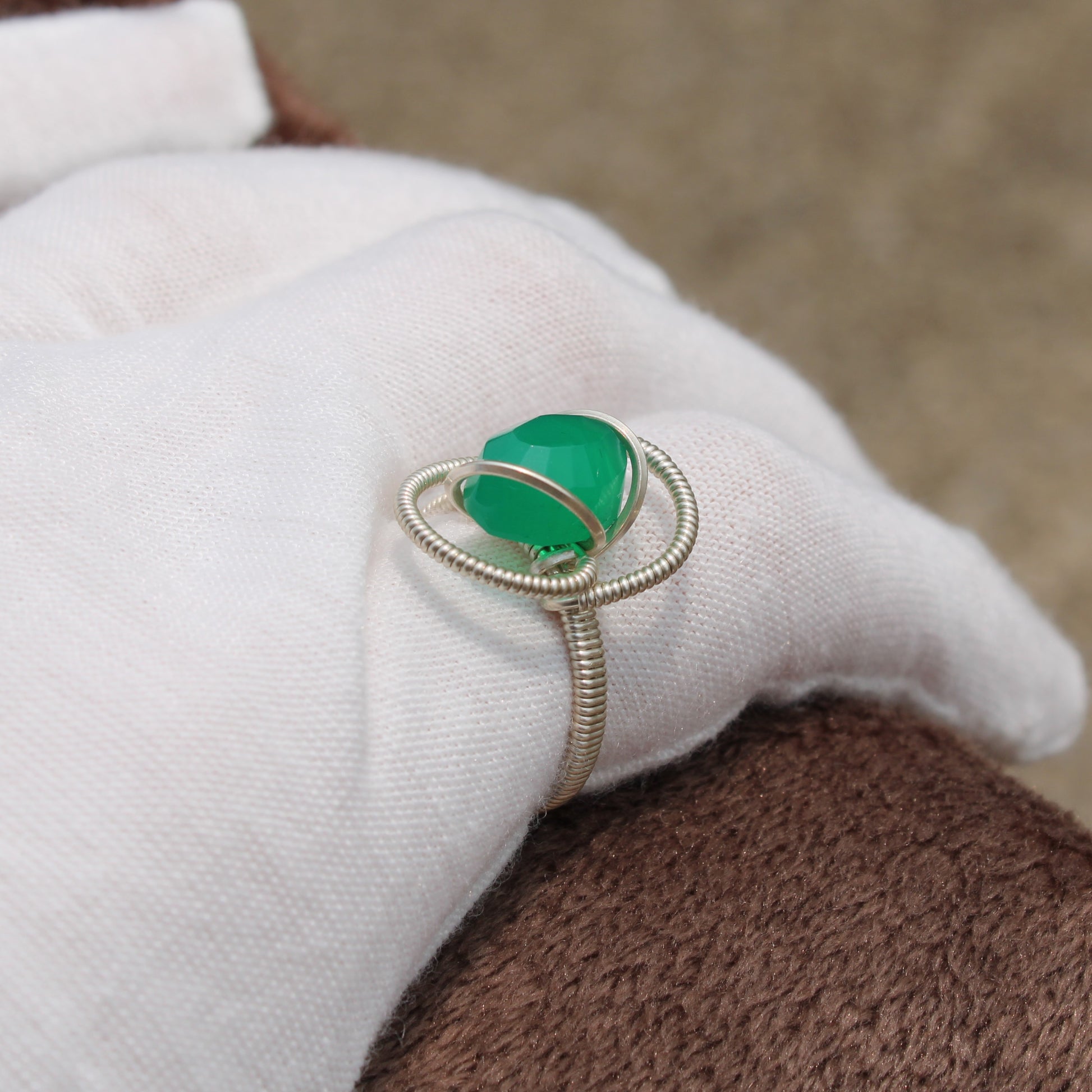 Elegant green onyx ring set in silver ring design, showcased on a white glove