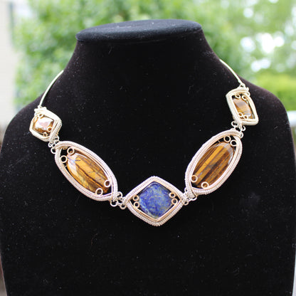 Handcrafted sterling silver necklace featuring colorful gemstones in unique settings