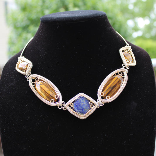 Handcrafted sterling silver necklace featuring colorful gemstones in unique settings