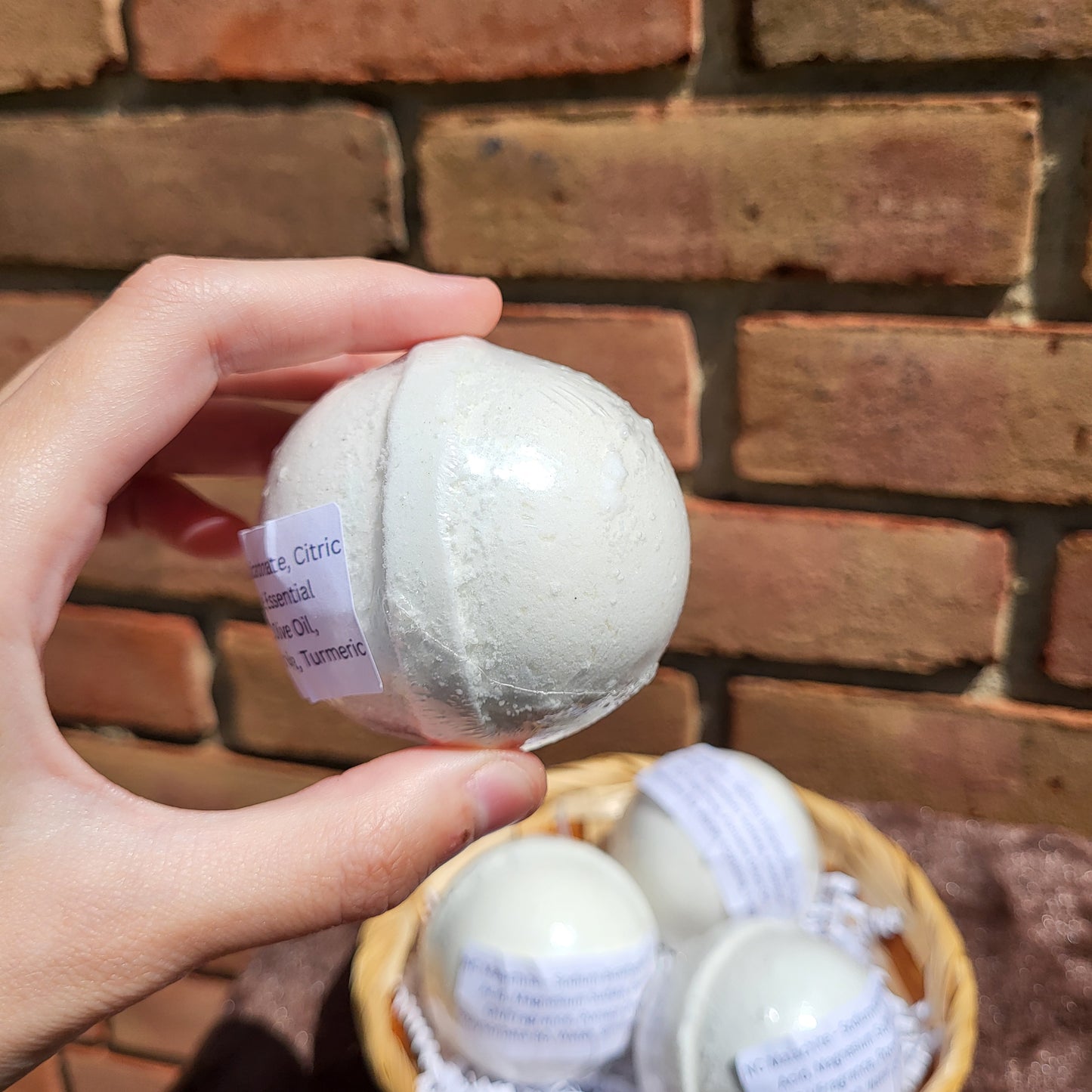 Made Natural Bath Bomb in hand, featuring Natural Color Cedarwood, Sweet Orange & Eucalyptus scent