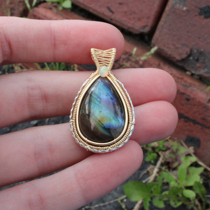 Labradorite 14k Gold Fill and Sterling Pendant held in hand, showcasing iridescent colors and elegant design