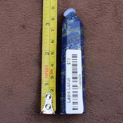 Lapiz Lazuli Tower crystal with blue and gold specks next to a measuring tape showing size