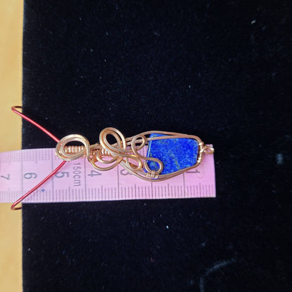 Lapis lazuli pendant wrapped in gold wire with decorative swirls for elegant jewelry collection