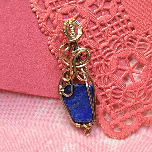 Lapis lazuli wire-wrapped pendant with intricate copper detailing for unique jewelry collection