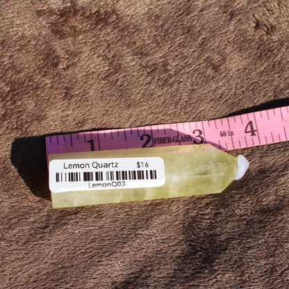 Lemon Quartz Tower from Different Branches LLC displaying a natural, yellow-green crystal shape with a price tag