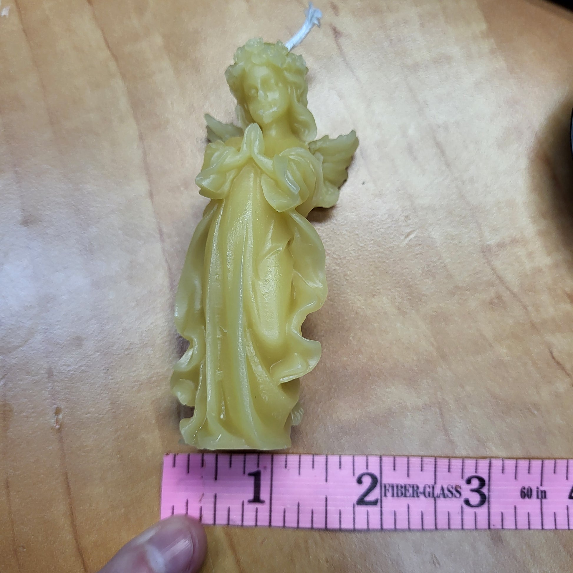 Little angel beeswax candle in yellow with intricate details and a charming design