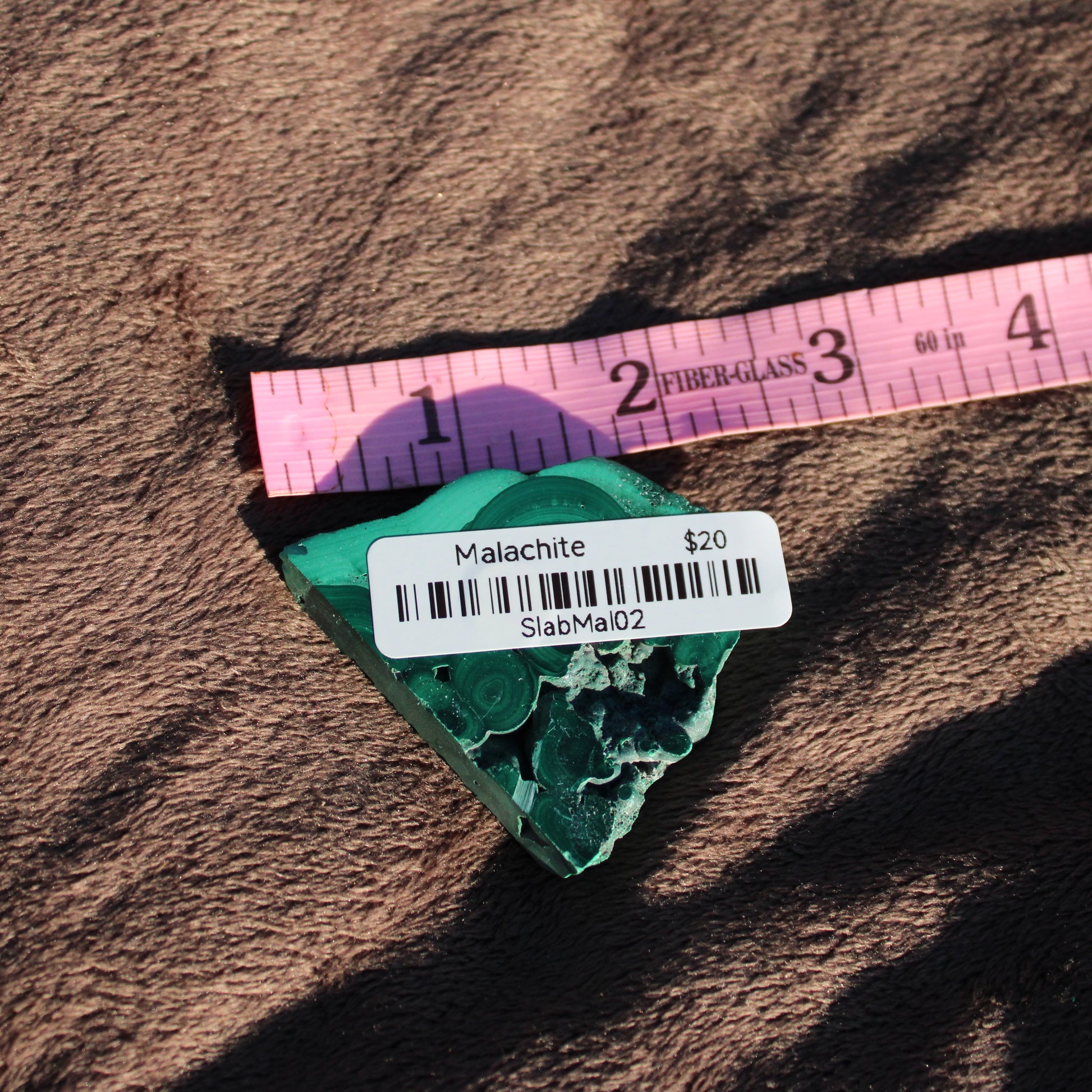 Natural Malachite slab showcasing vibrant green patterns, perfect for decorative use or crystal healing.