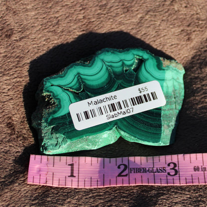 Malachite slab featuring vibrant green hues and unique banding, ideal for collectors or decorative use
