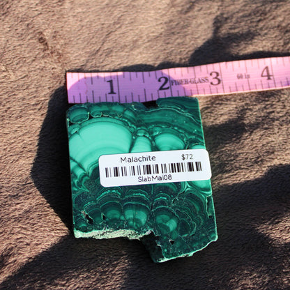 Natural Malachite slab showcasing vibrant green patterns with price tag from Different Branches LLC