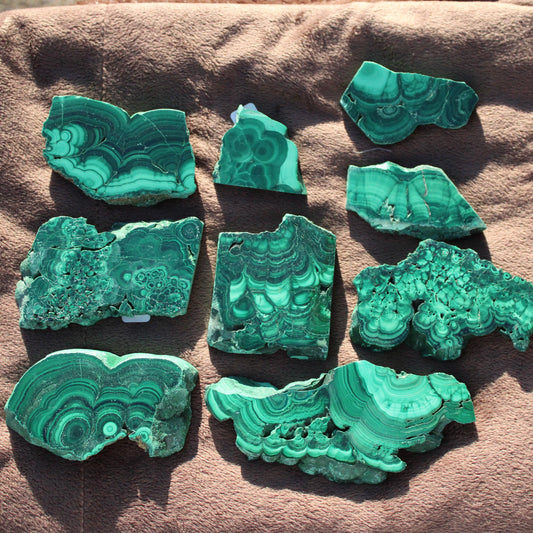 Array of Malachite slab pieces showing natural green patterns and textures for collectors and decor