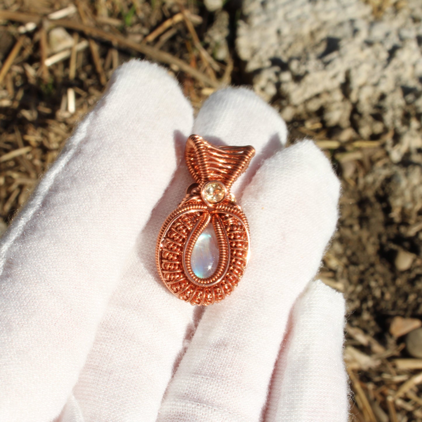 Mini rainbow moonstone copper pendant featuring intricate design and shimmering details