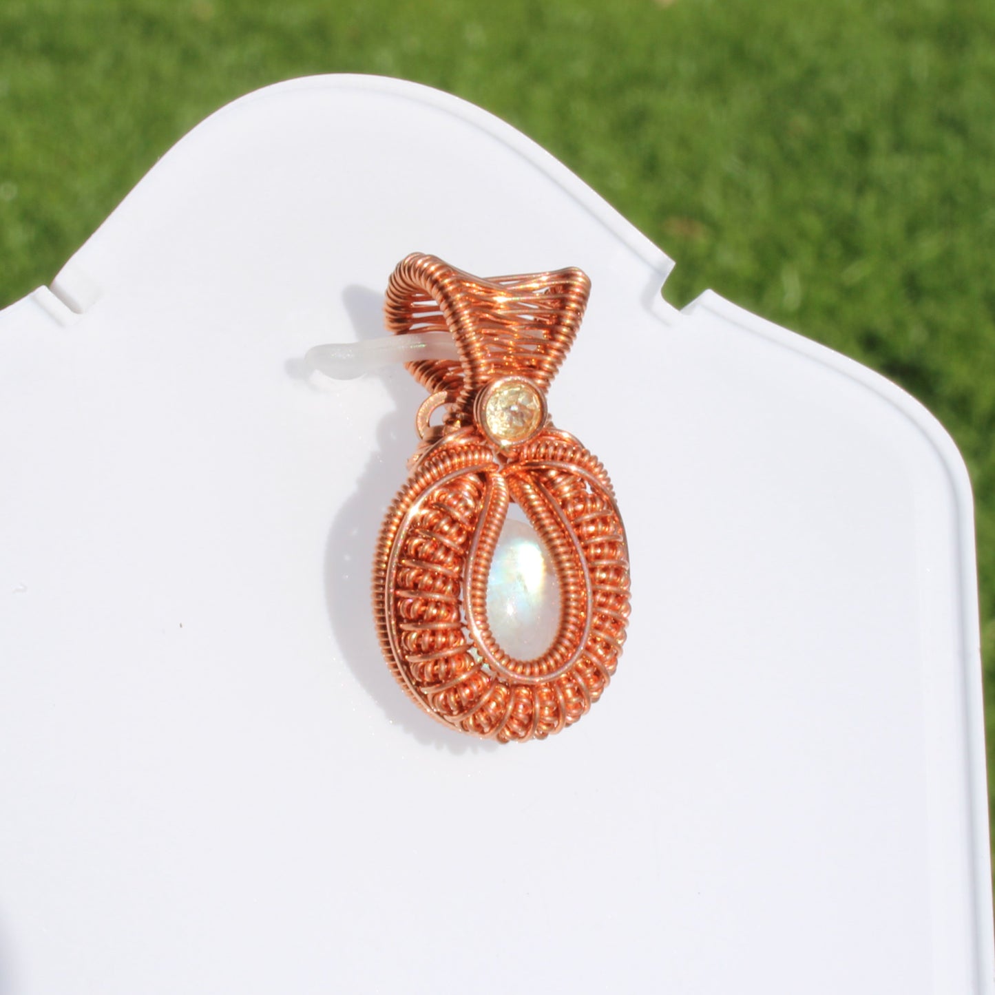 Mini rainbow moonstone copper pendant with intricate wire design, perfect for stylish jewelry lovers