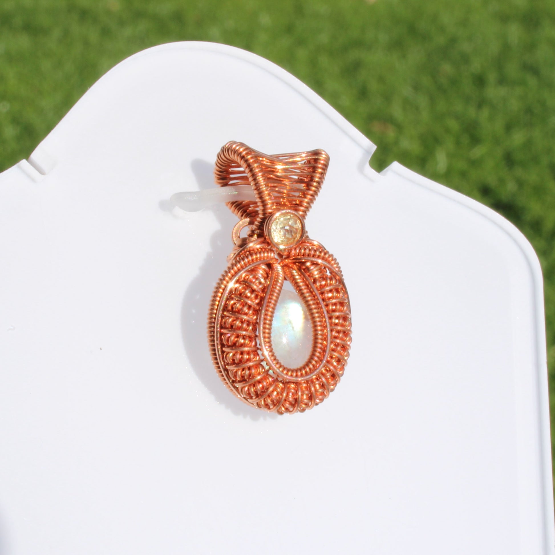Mini rainbow moonstone copper pendant with intricate wire design, perfect for stylish jewelry lovers