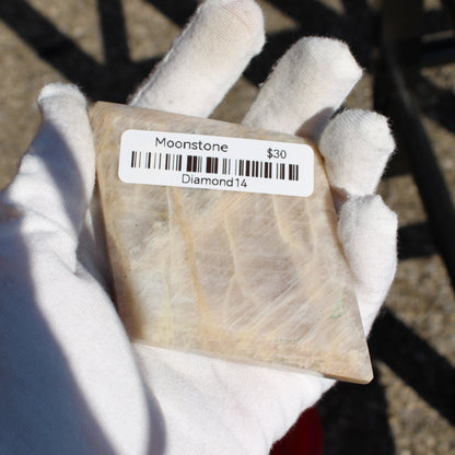 Natural Moonstone diamond in hand, showcasing its unique translucent beauty and raw texture