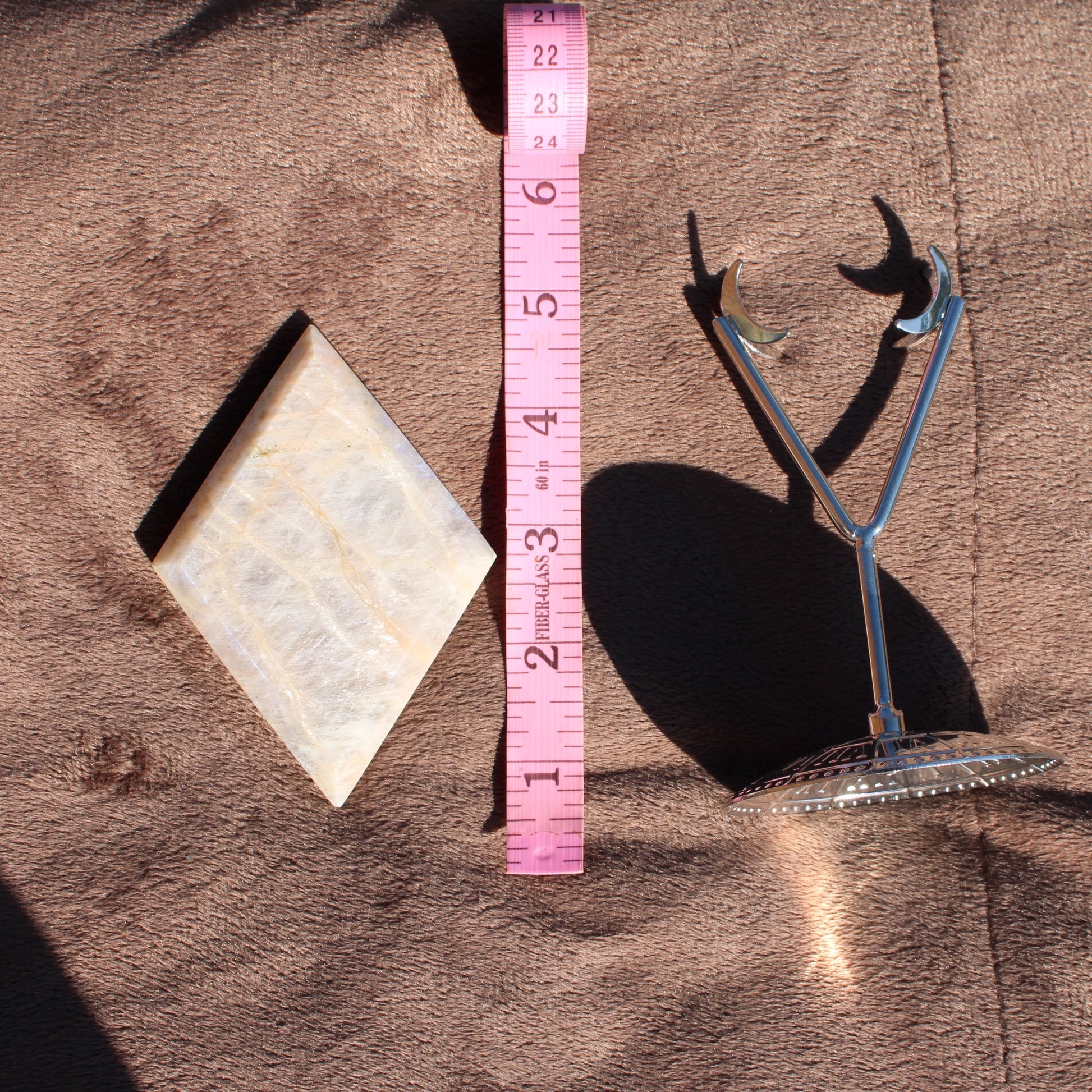 Natural Moonstone Diamond Crystal with a polished finish and a measuring tape for scale