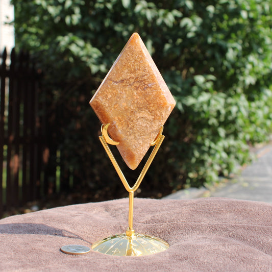 Moss Agate Diamond crystal on gold metal stand displayed outdoors by Different Branches LLC