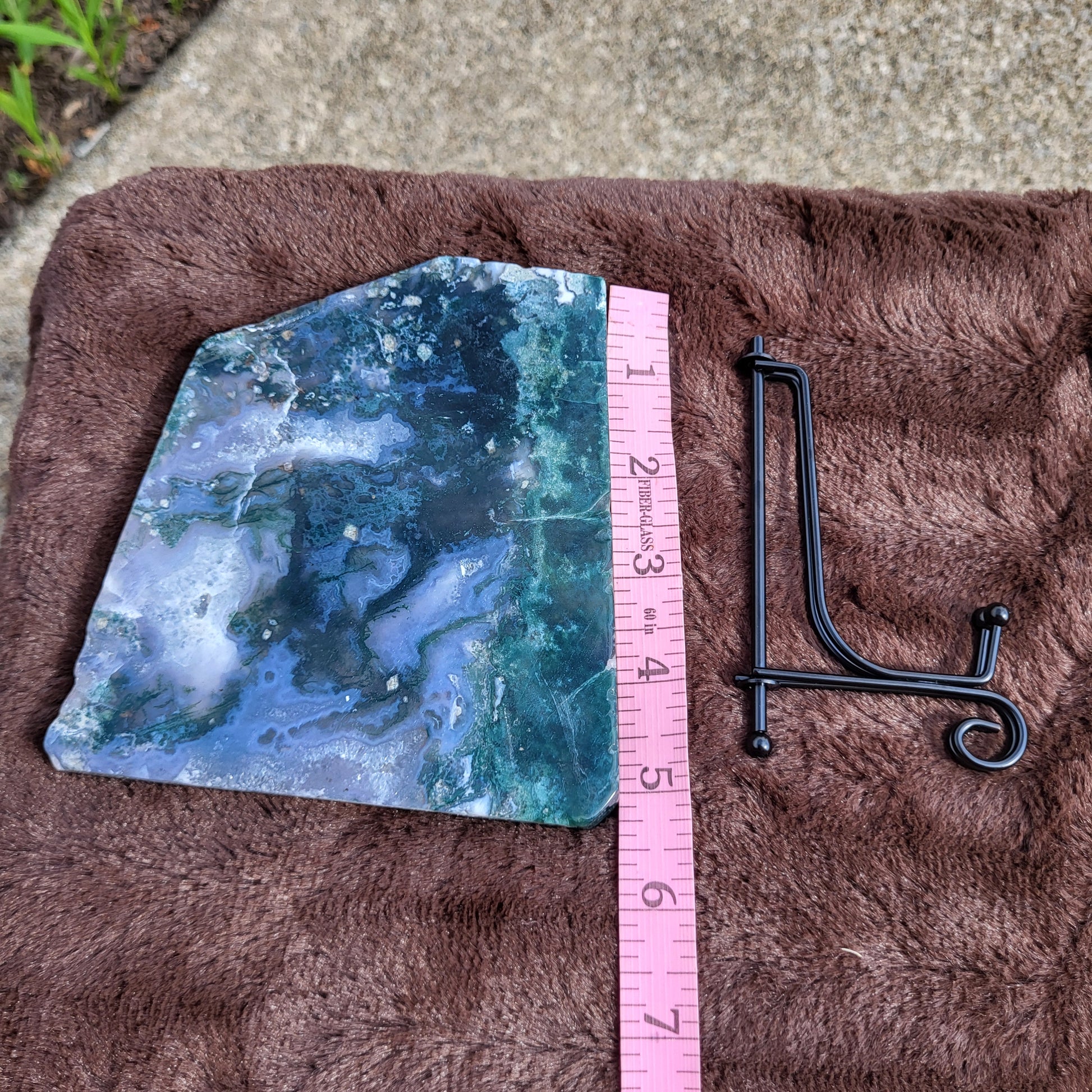 Moss Agate Slab with Unique Patterns and Colors next to a Display Stand for Decorative Use