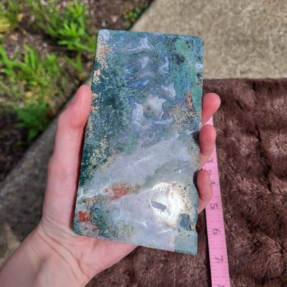 Moss Agate Slab displayed in hand, showcasing unique green patterns and natural beauty