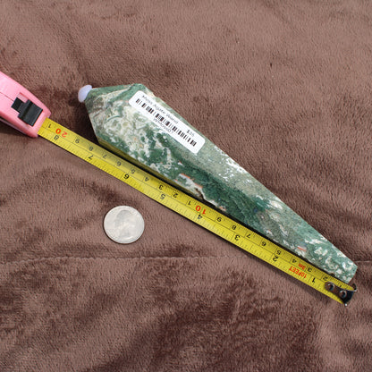 Green and white Moss Agate Wand from Different Branches LLC next to a tape measure and coin for size reference