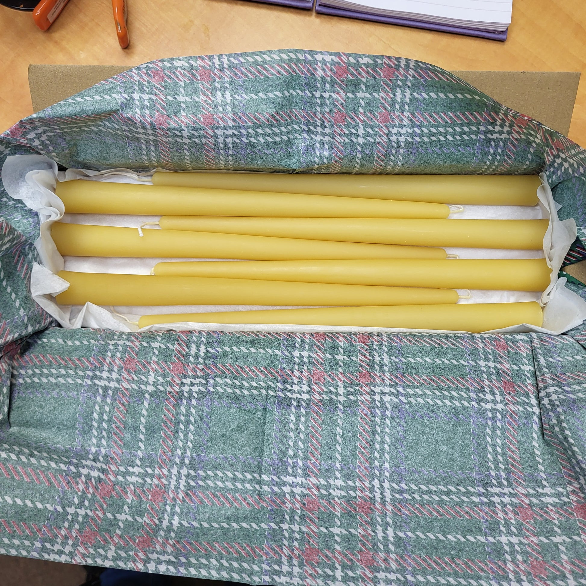 Box of natural beeswax candlesticks by the box, beautifully wrapped in festive paper