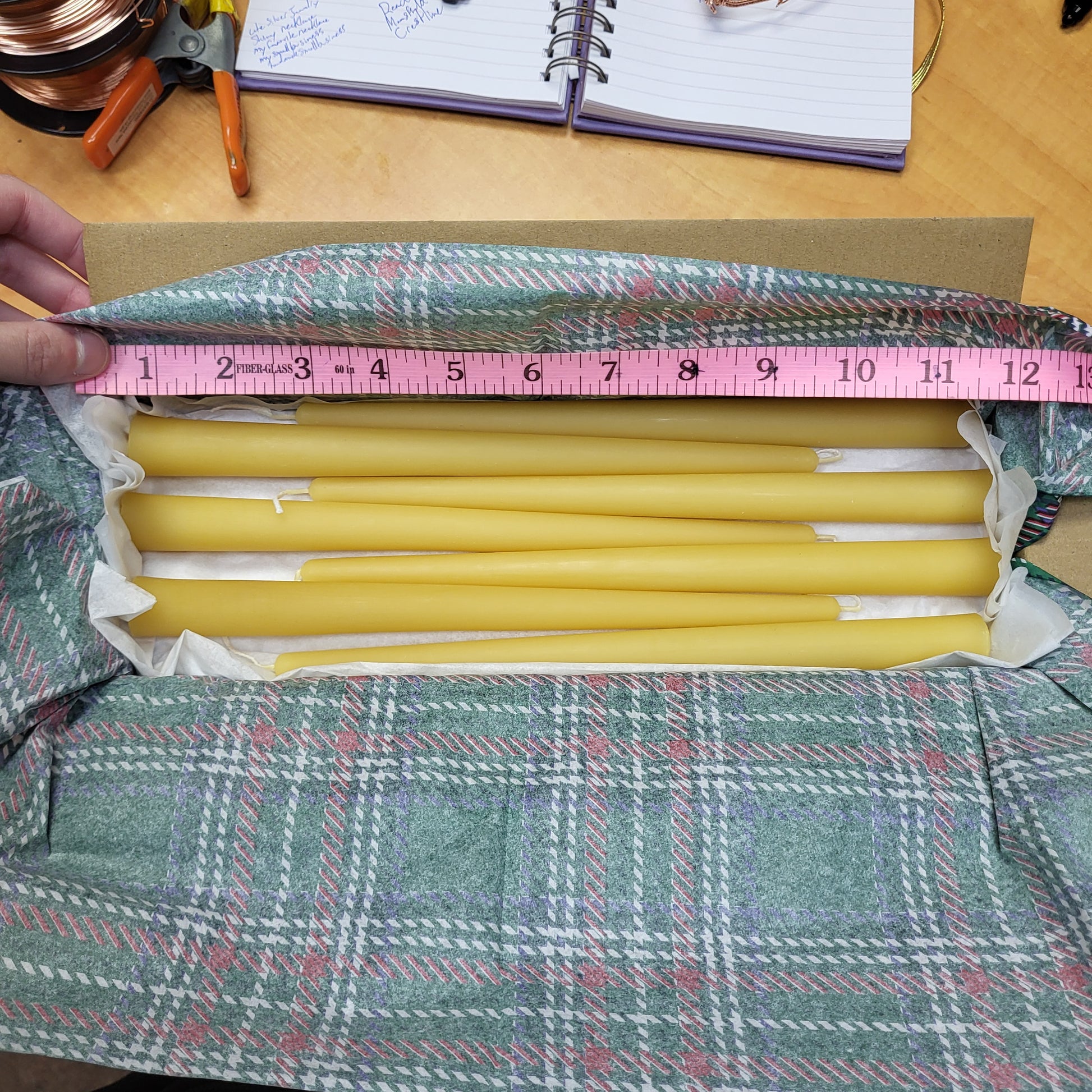 Natural beeswax candlesticks by the box arranged neatly in protective packaging for safe storage