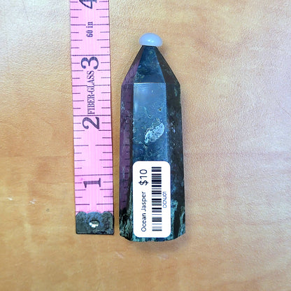 Ocean jasper tower in unique colors, standing next to a ruler for size reference