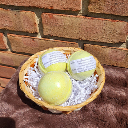 Three Peridot Bath Bombs in a wicker basket filled with decorative shreds for a relaxing soak