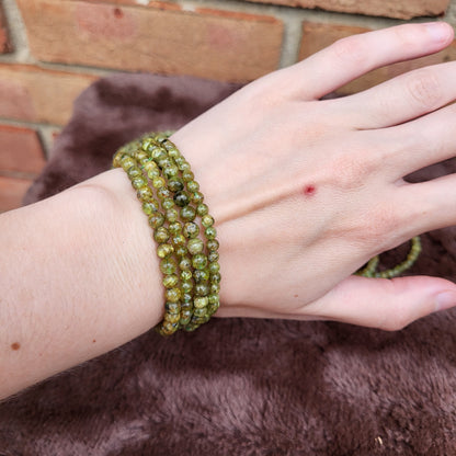 Peridot bracelet displayed on a hand showcasing its vibrant green color and natural stone texture