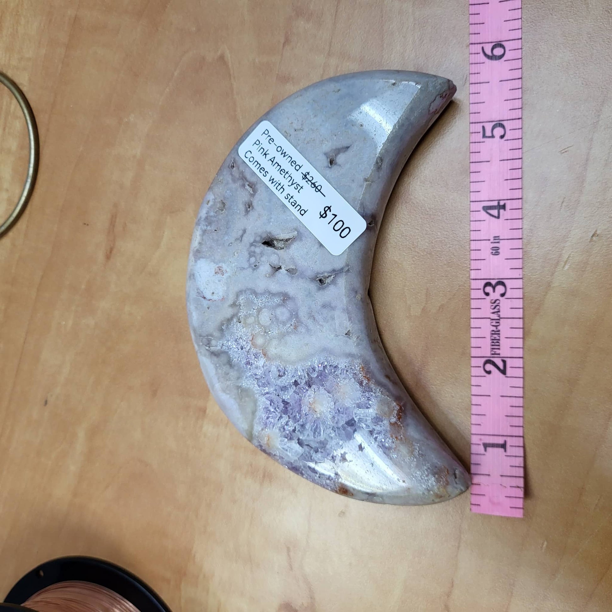 Pink Amethyst Moon with Stand displayed on a wooden surface showcasing its unique crystal design