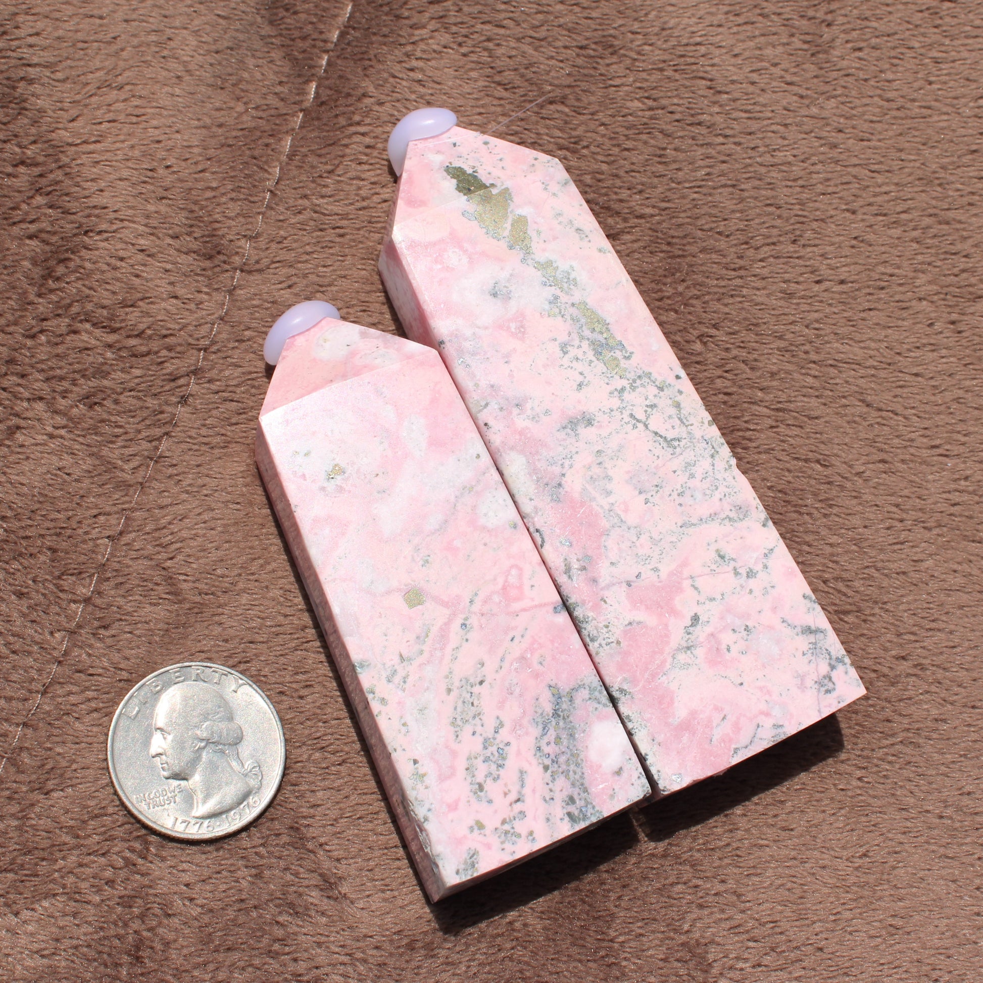 Two polished Pink Opal Tower crystals with natural white and gray patterns displayed beside a quarter for size reference