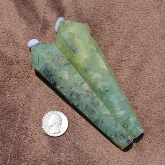 Two polished Prehnite Wand crystals in green hues next to a US quarter for size reference