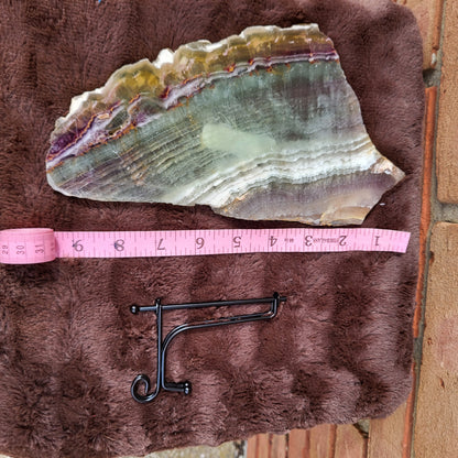 Rainbow Flourite Slab displayed with a measuring tape for size reference on a soft surface