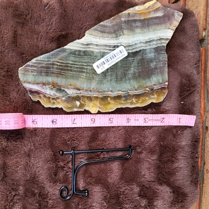 Rainbow Flourite Slab displayed on plush surface with measurement tool for size reference