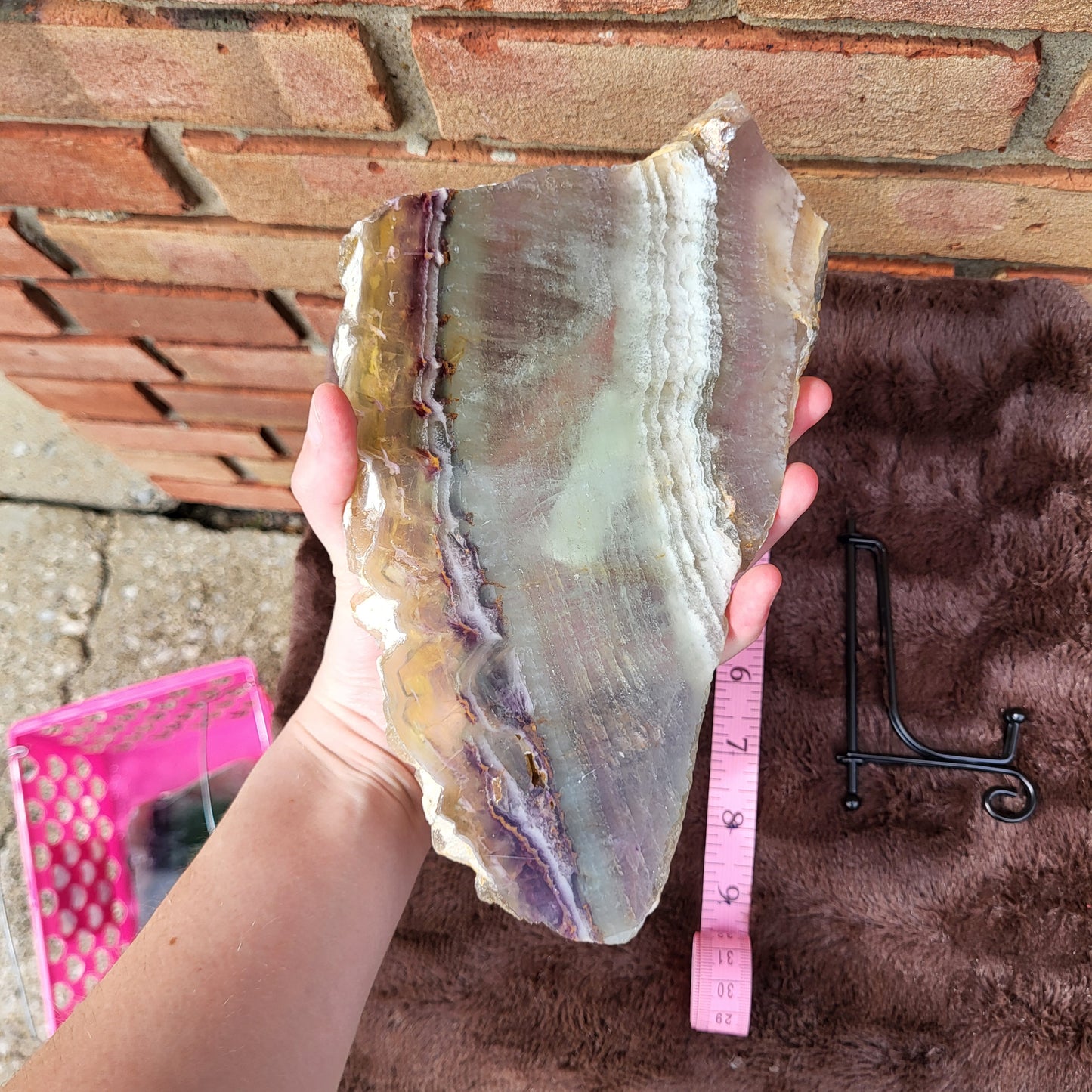 Hand holding a large Rainbow Flourite Slab showcasing vibrant colors and natural patterns