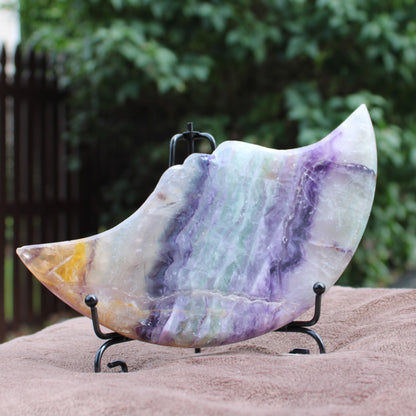 Rainbow Fluorite Cresent Moon Statement Crystal with purple and green hues on display stand